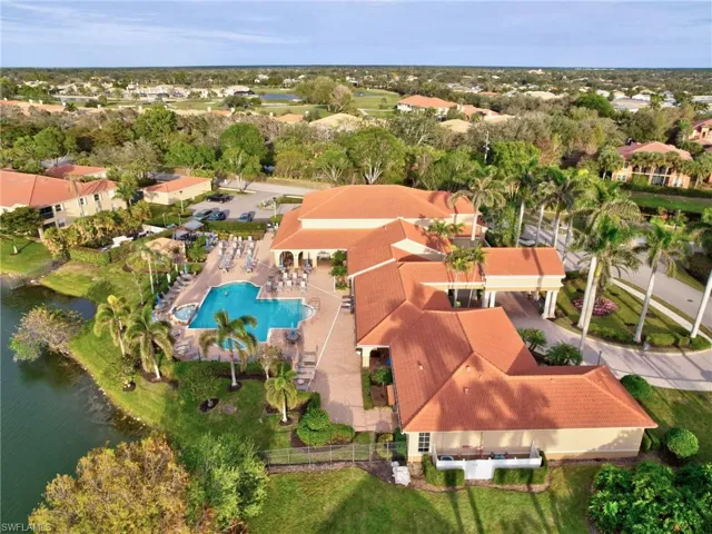 Aerial view of residential area with a large body of water and a pool