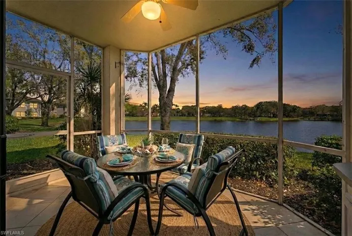 Sunroom with outdoor dining area, a ceiling fan, and a water view