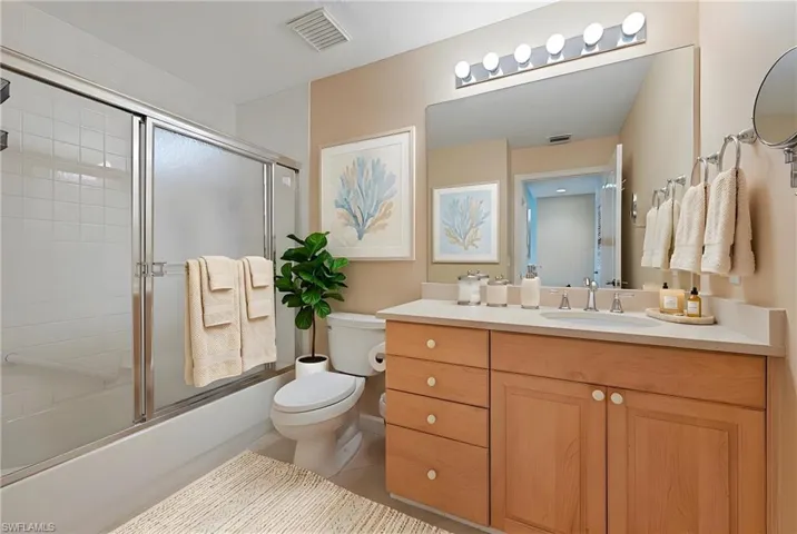Full bathroom with vanity and bath / shower combo with glass door