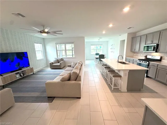 Living room with ceiling fan and sink