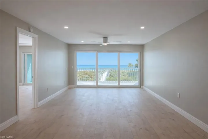 Unfurnished room featuring light wood-style flooring, ceiling fan, recessed lighting, and a water view