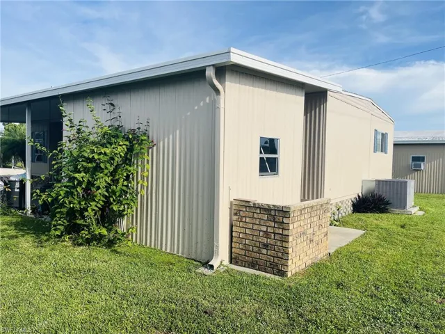 View of home's exterior with a yard and crawl space