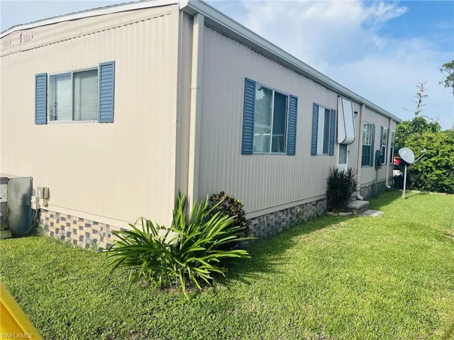 Manufactured / mobile home with a front lawn and entry steps