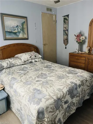 Bedroom with a textured ceiling, wood finished floors, and a ceiling fan