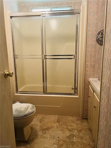 Bathroom featuring wallpapered walls and vanity