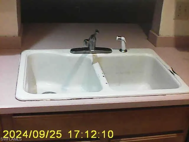 Kitchen view of a sink and light countertops