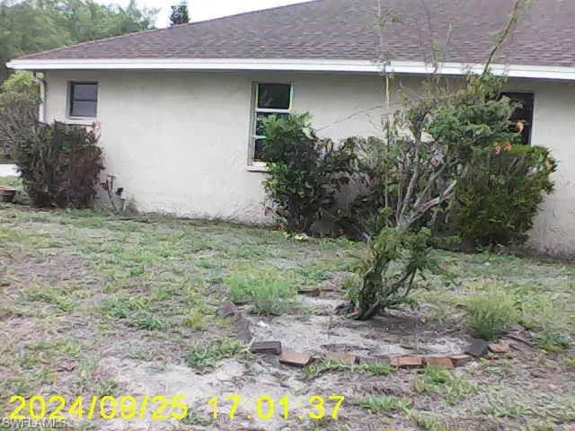 View of side of property featuring stucco siding and a shingled roof