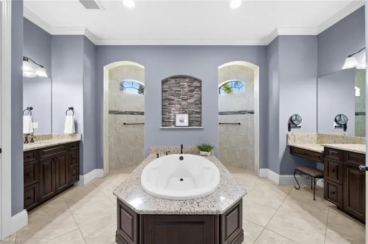 Primary bathroom with dual sinks and walk-through shower and soaking tub
