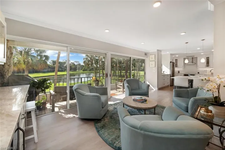 Living room with ornamental molding, a water view, and hardwood / wood-style floors