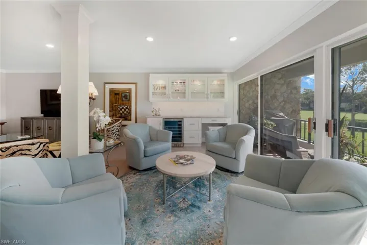 Living room with wine cooler, ornamental molding, and decorative columns