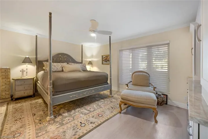 Bedroom featuring ceiling fan, hardwood / wood-style floors, and ornamental molding