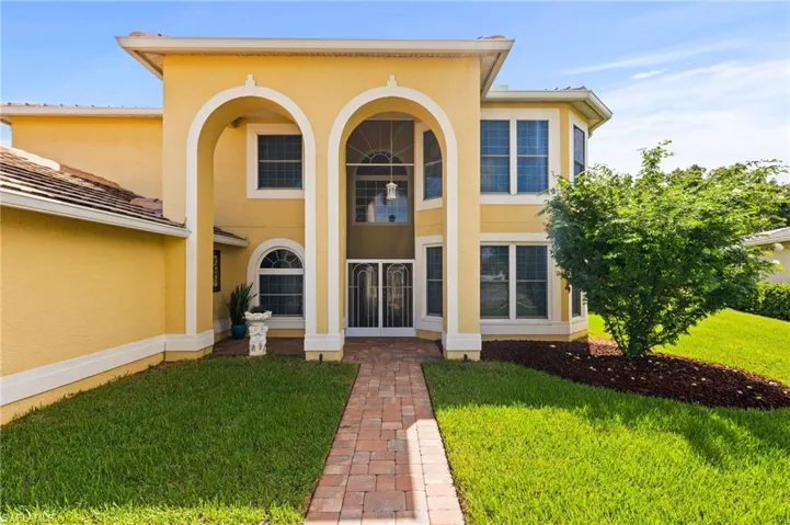 Formal Two Story Entry with paver stone walkway, driveway & front patio