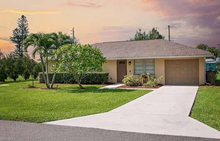 Single story home with stucco siding, an attached garage, concrete driveway, and a front yard