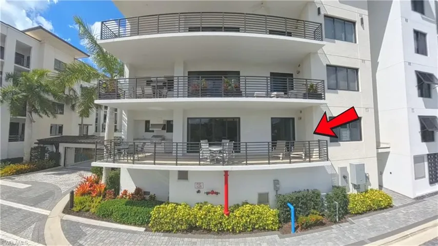 Spacious private balcony with black horizontal railings, an outdoor kitchen featuring a built-in grill, and ample space for outdoor dining
