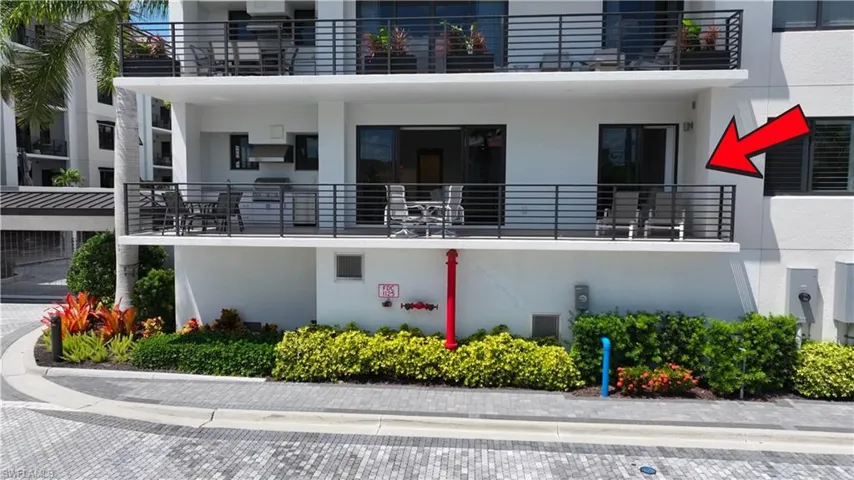 Upper-level balcony featuring contemporary horizontal metal railings, built-in outdoor grill station, and glass sliding door access