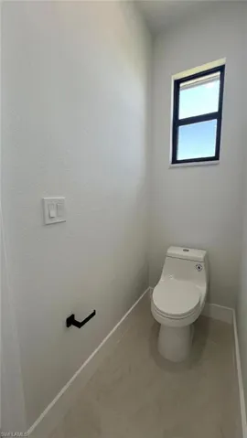Bathroom featuring toilet and baseboards