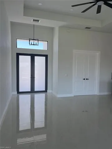 Foyer featuring a tray ceiling, baseboards, and visible vents