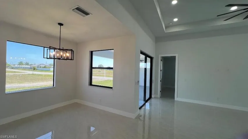 Unfurnished room featuring baseboards, visible vents, a notable chandelier, and recessed lighting