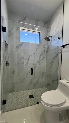 Bathroom featuring toilet and a stall shower