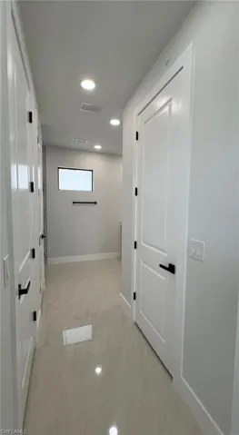 Hallway featuring baseboards, visible vents, and recessed lighting