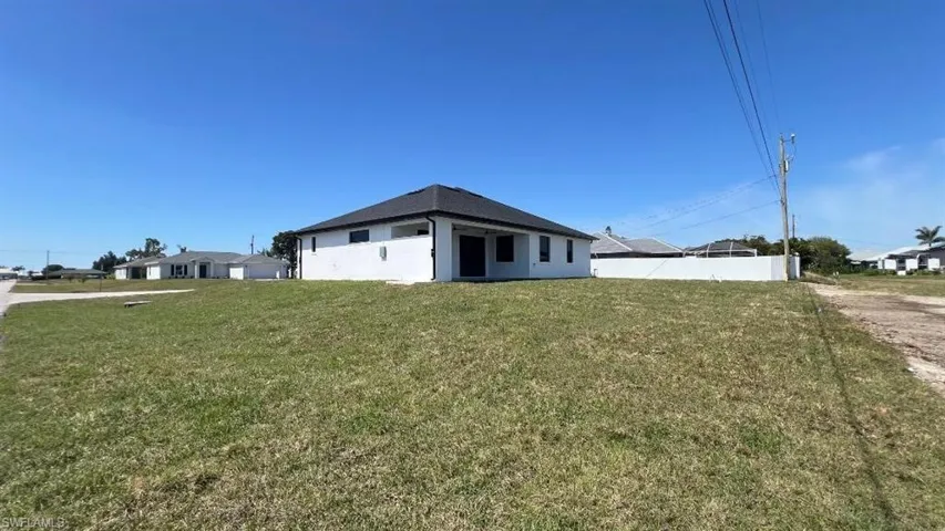 View of home's exterior featuring a lawn, fence, and stucco siding