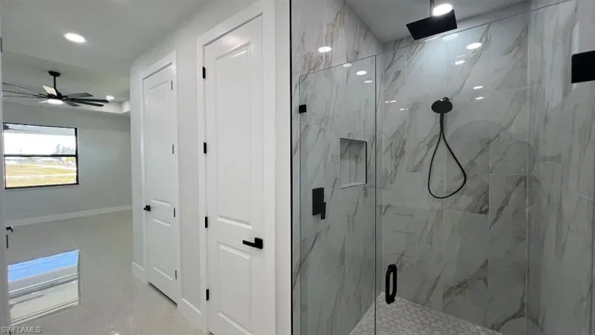 Full bath with a ceiling fan, a marble finish shower, baseboards, and recessed lighting