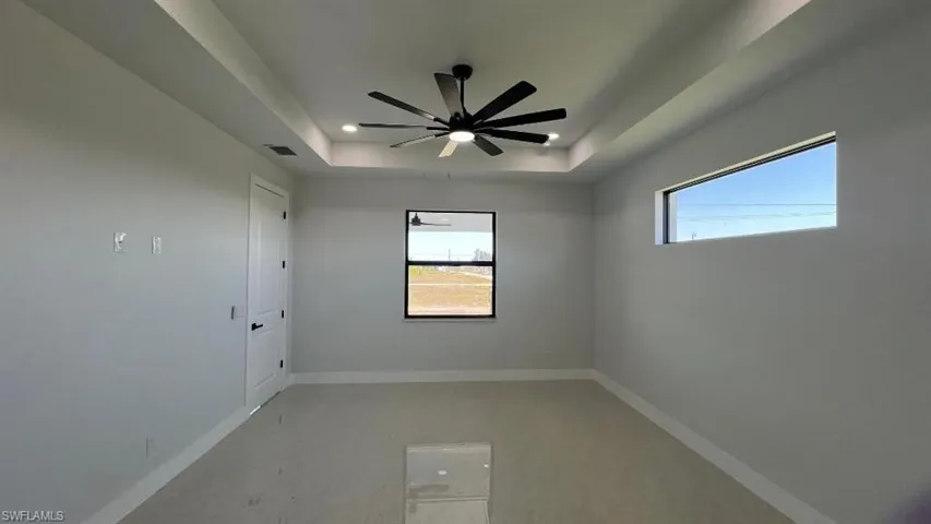Spare room featuring visible vents, baseboards, ceiling fan, recessed lighting, and a raised ceiling