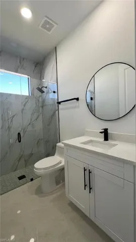 Full bath featuring visible vents, marble finish floor, a marble finish shower, toilet, and vanity