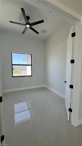 Spare room with baseboards, ceiling fan, and visible vents