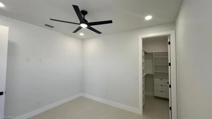 Unfurnished bedroom with recessed lighting, a spacious closet, baseboards, visible vents, and a closet