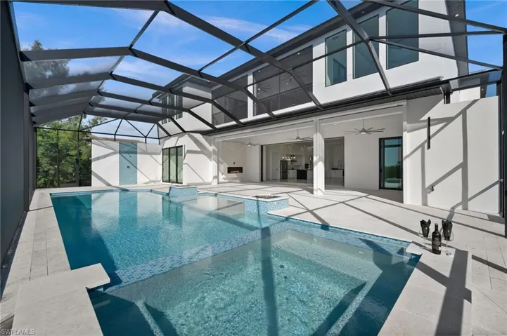Integrated pool / spa featuring a sunroom, a patio area, and a lanai