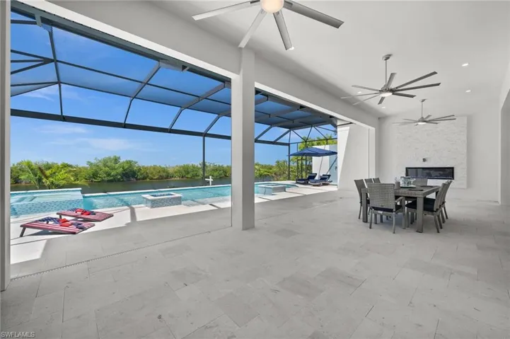 Integrated pool / hot tub featuring a lanai, a patio, outdoor dining area, and a sunroom