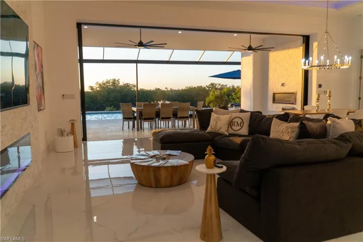 Living room with a chandelier, a fireplace, healthy amount of natural light, and ceiling fan