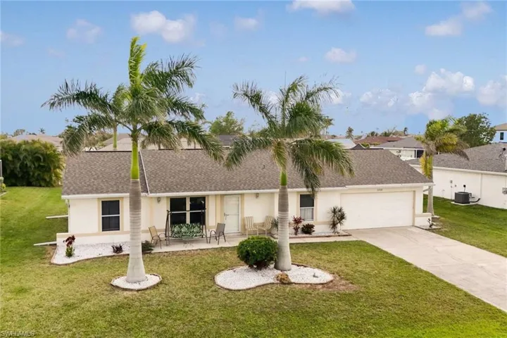 Ranch-style home with stucco siding, a garage, concrete driveway, and a front lawn