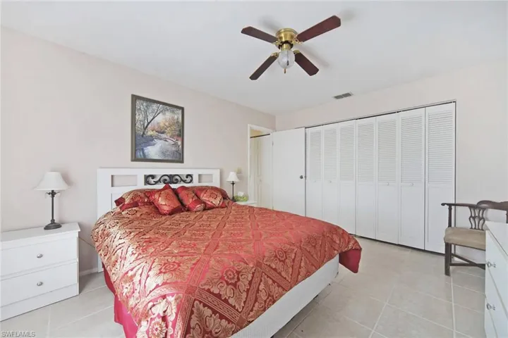 Bedroom with light tile  floors, visible vents, and ceiling fan