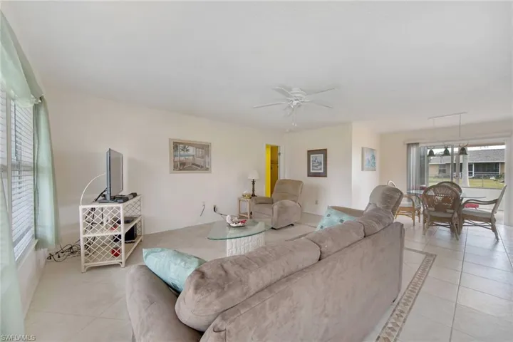 Living room featuring light tile floors and a ceiling fan