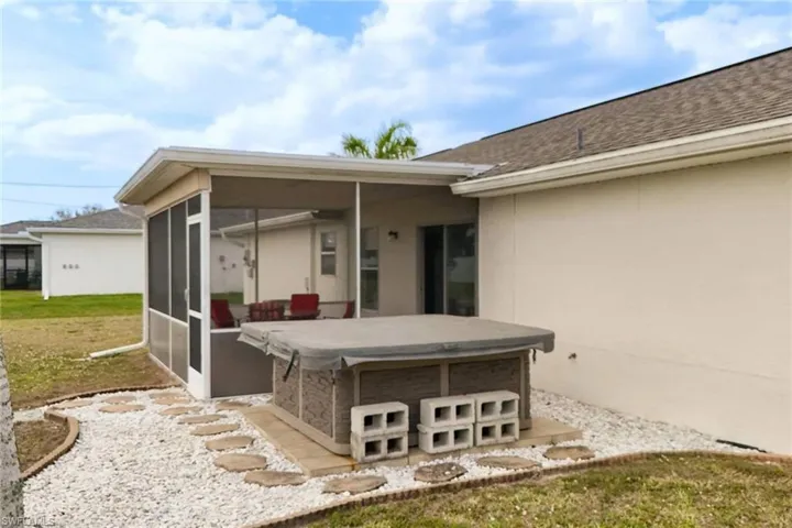 View of patio / terrace featuring a sunroom and a hot tub