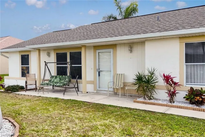 Property entrance featuring stucco siding and roof with shingles