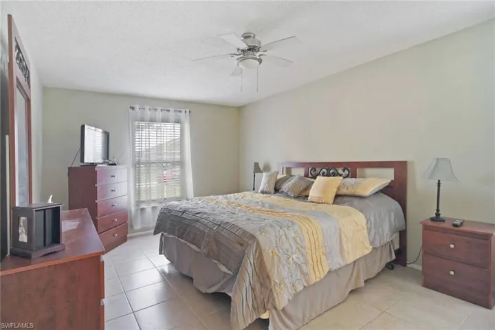 Bedroom featuring tile  flooring, a ceiling fan, and a textured ceiling