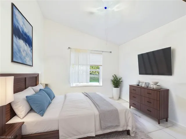 Tiled bedroom featuring lofted ceiling