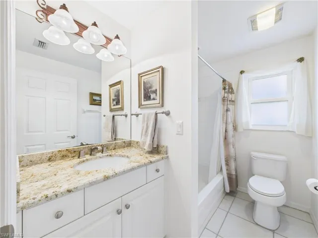Full bath with toilet, tile patterned flooring, visible vents, and vanity