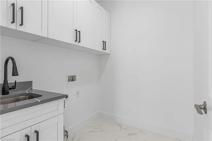 Washroom featuring cabinets, washer hookup, electric dryer hookup, and sink