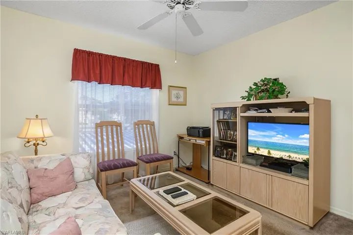 Living room featuring carpet floors, a textured ceiling, and a ceiling fan