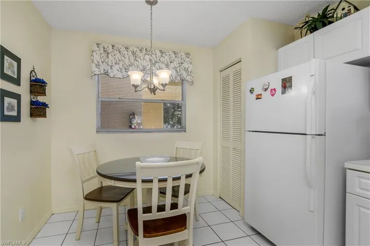 Dining space with light tile patterned flooring and a chandelier