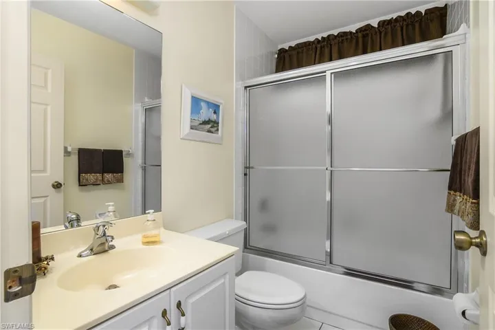 Full bath featuring vanity, combined bath / shower with glass door, and tile patterned floors