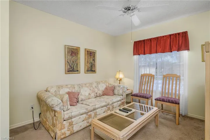 Carpeted living area with a textured ceiling and a ceiling fan