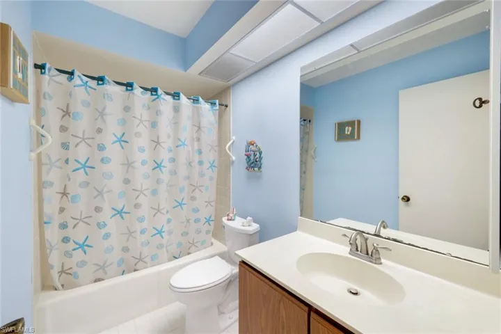 Full bathroom with vanity, tile patterned floors, toilet, and shower / bathtub combination with curtain