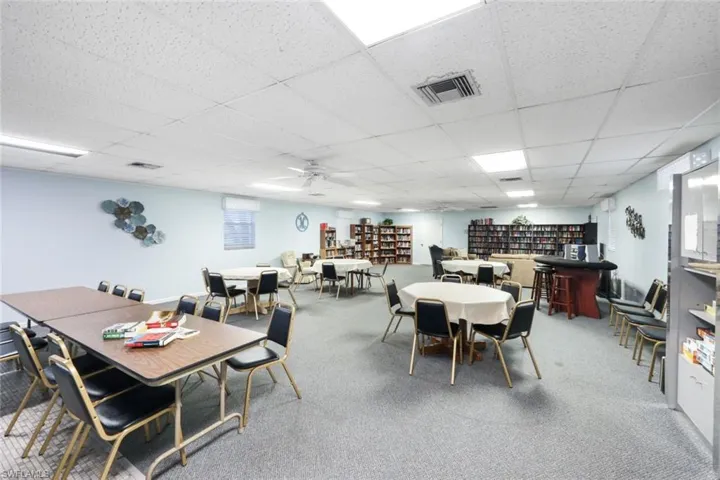 Dining area with a paneled ceiling, carpet floors, and ceiling fan