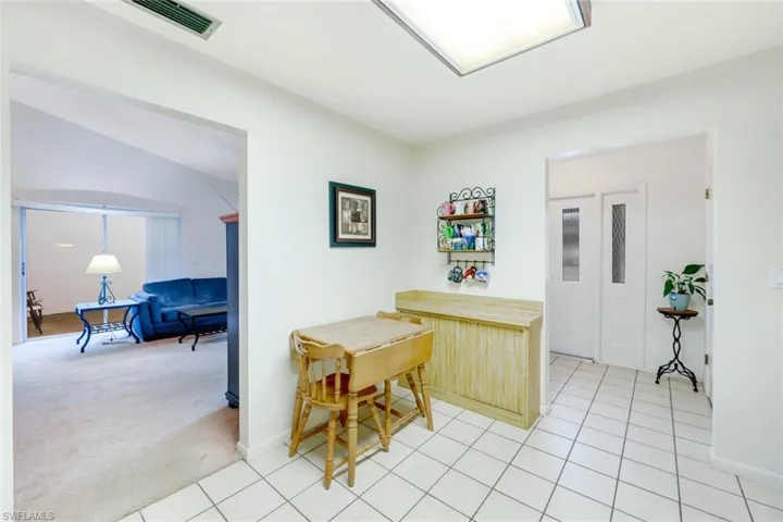 Kitchen with vaulted ceiling and light carpet