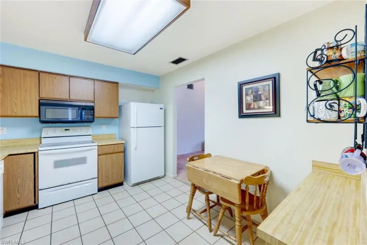 Kitchen featuring light tile patterned floors and white appliances